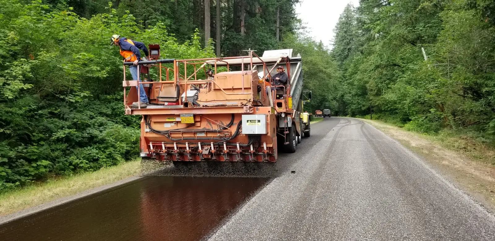 A truck applying a surface treatment to a rural road