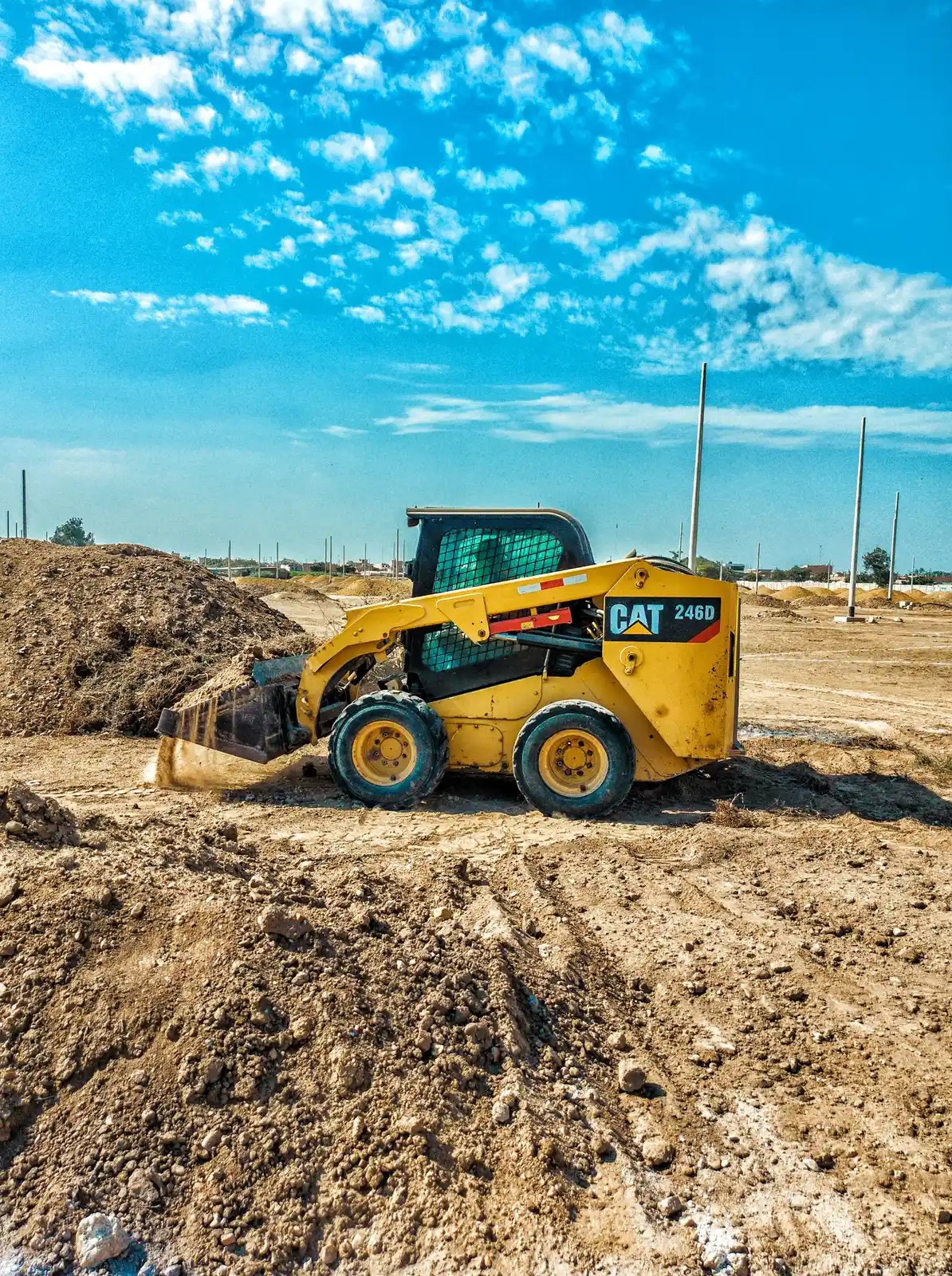 A skid steer grading a site before paving